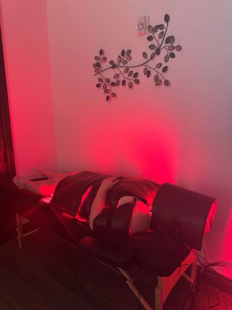 A massage table illuminated by soft red light in a tranquil room setting.